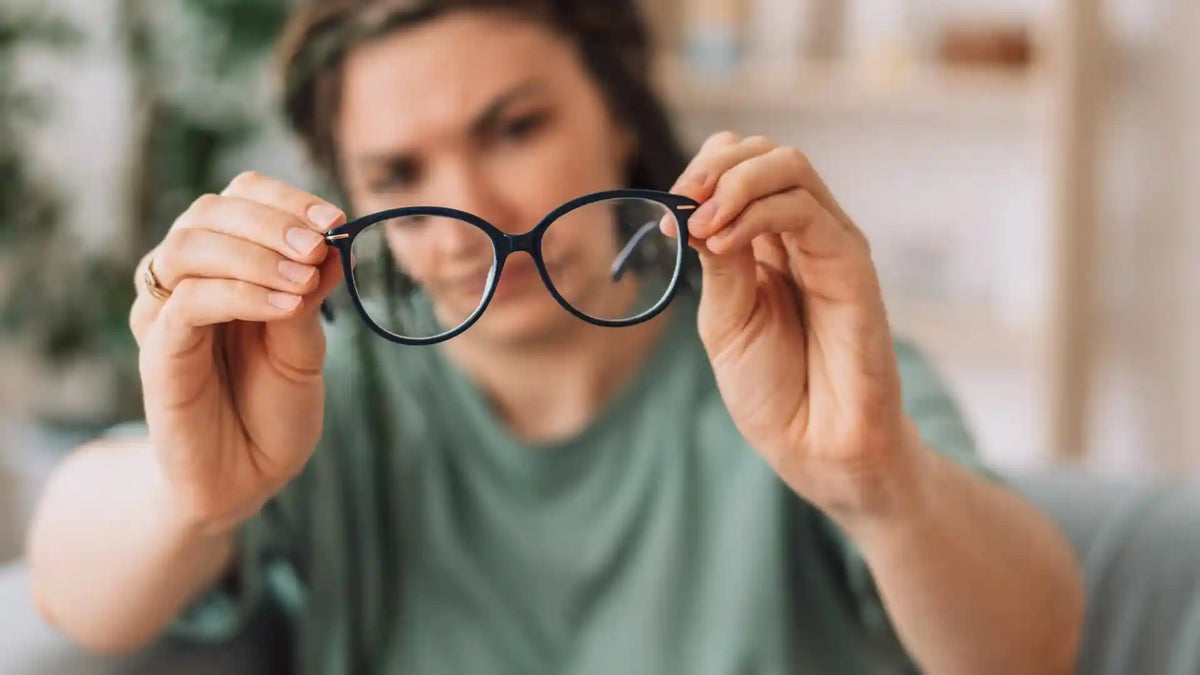 Frau mit Brille in den Händen